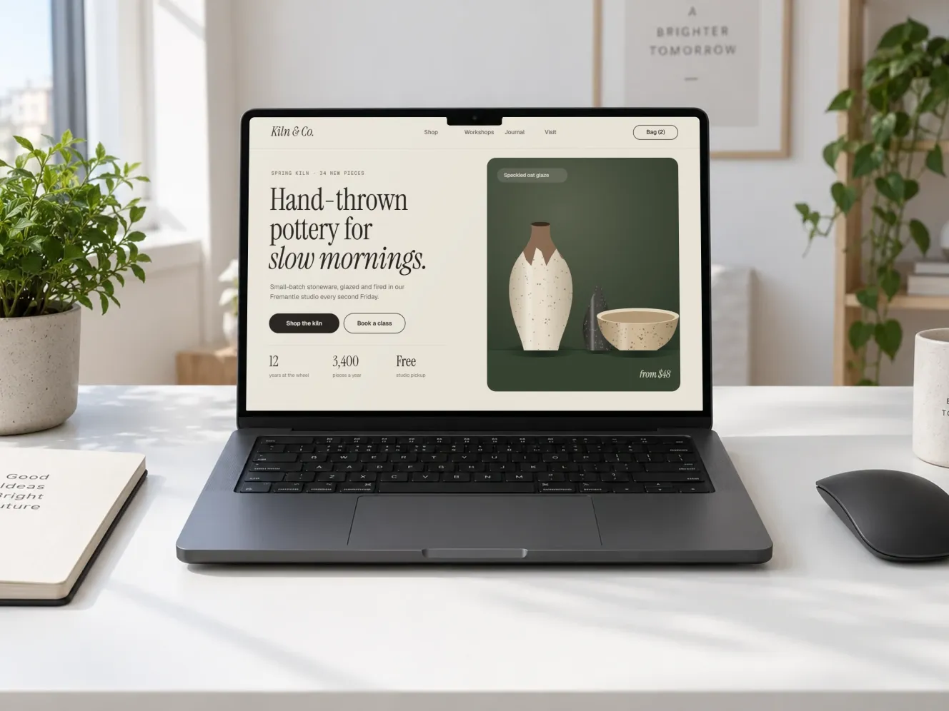 A website design shown on a MacBook Pro on a white desk